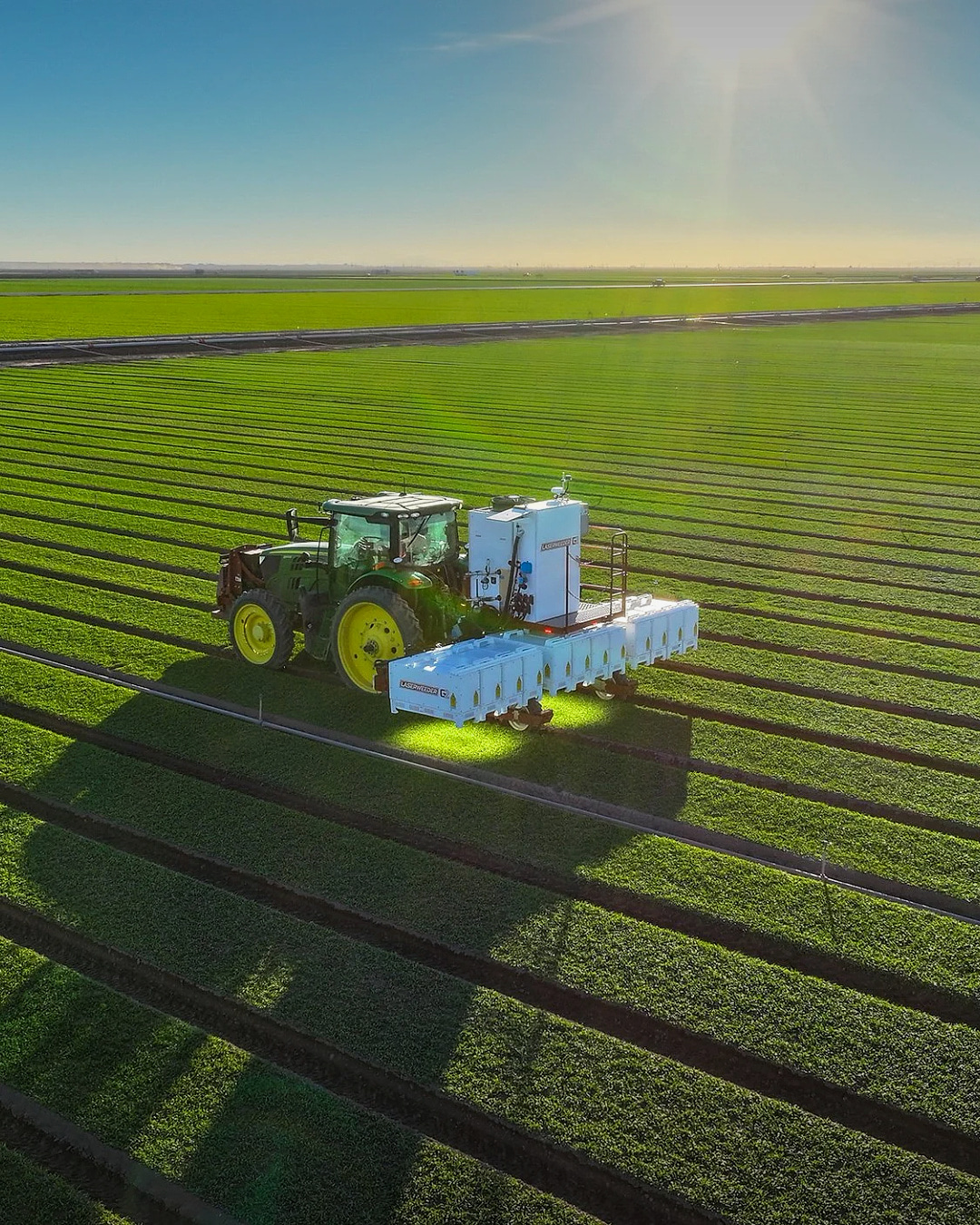 Carbon Robotics LaserWeeder G2 moving above rows of green crops in a field